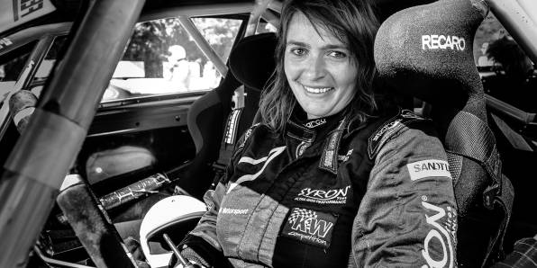 Corinna sitzt im Rennanzug im Rennauto.