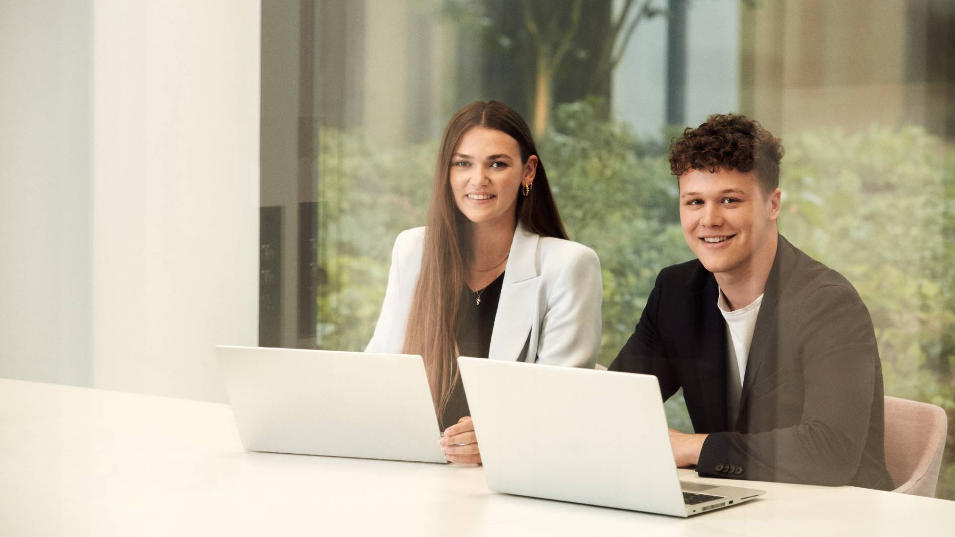 Werkstudenten arbeiten am Tisch miteinander