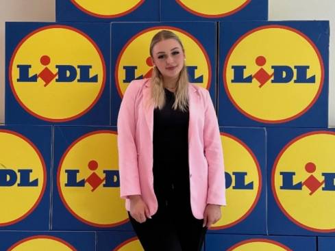 Azubine Elisabeth vor einer Wand mit Lidl Logos