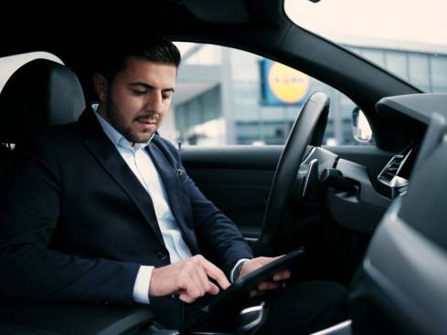 Verkaufsleiter im Auto mit Tablet