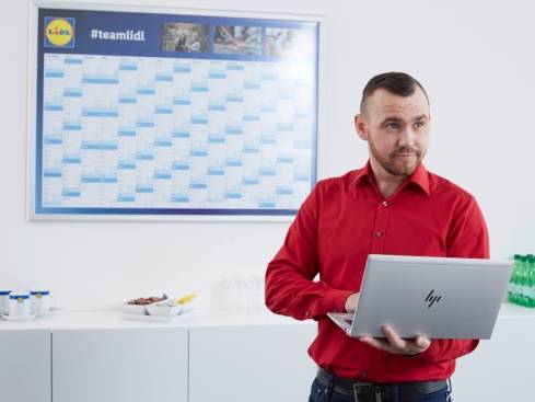 Lidl Kollege hält einen Vortrag mit einem Laptop