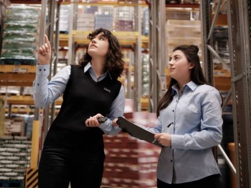 Teamleiterin mit Studentin im Logistiklager