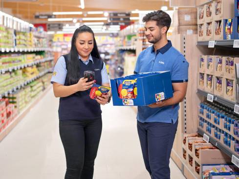 Filialleiterin prüft mit Dualem Studenten Produkte.