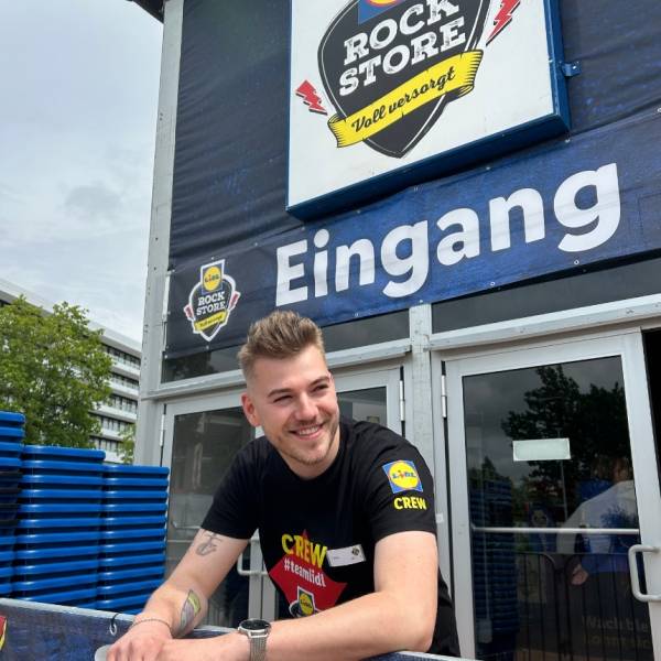 Azubi vor dem Eingang des Rock Stores 2025