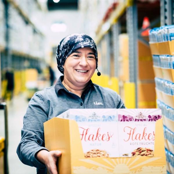 Lidl Mitarbeiterin Aishe trägt einen Karton