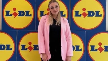 Azubine Elisabeth vor einer Wand mit Lidl Logos